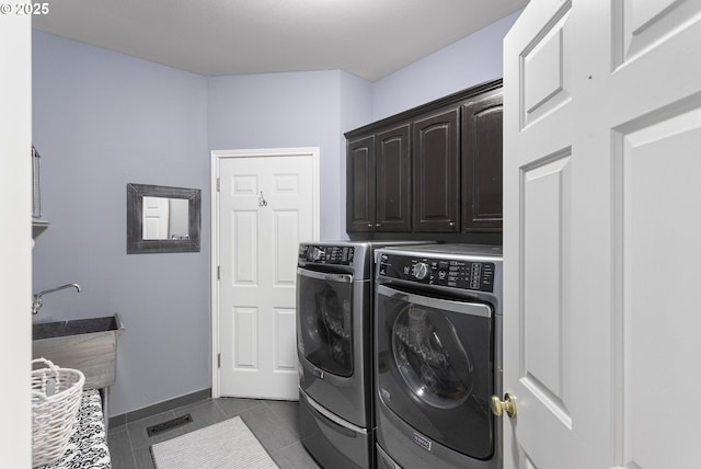12453 SW Sheldrake Way, Beaverton, OR 97007 - laundry area with cabinet space, washer and dryer, and dark tile patterned floors