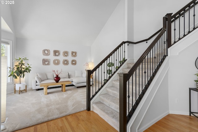 12453 SW Sheldrake Way, Beaverton, OR 97007 - stairs featuring high vaulted ceiling, wood finished floors, and baseboards
