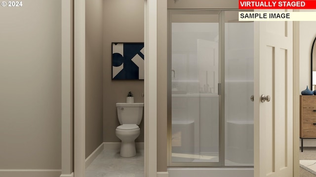 full bathroom featuring baseboards, toilet, and a stall shower