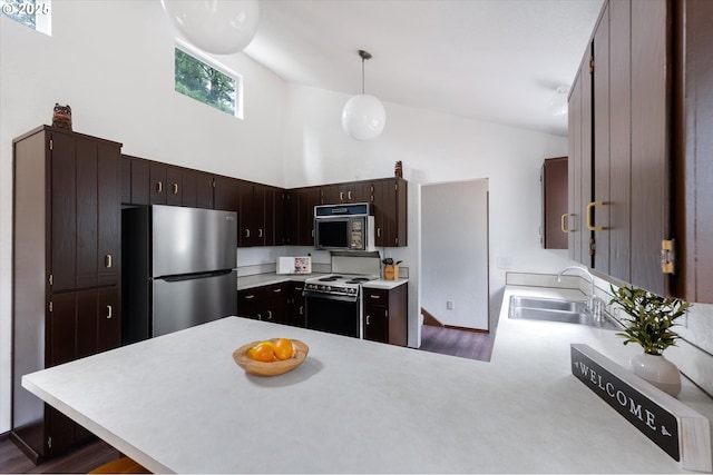 kitchen with kitchen peninsula, decorative light fixtures, stainless steel refrigerator, white electric range, and sink