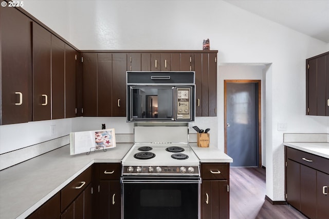 kitchen with electric range oven, lofted ceiling, dark brown cabinets, and dark hardwood / wood-style floors