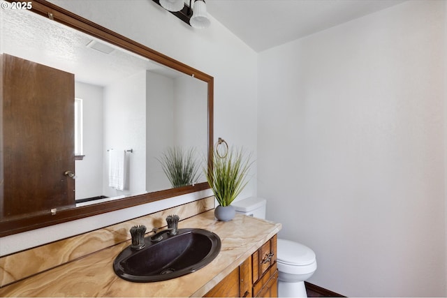 bathroom featuring toilet and vanity