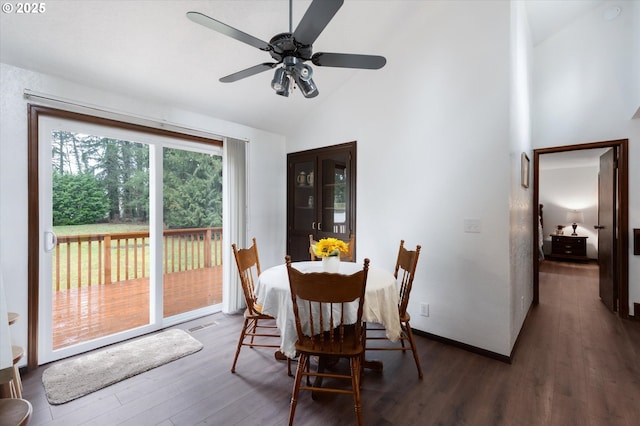 dining area featuring ceiling fan, high vaulted ceiling, and dark wood-type flooring