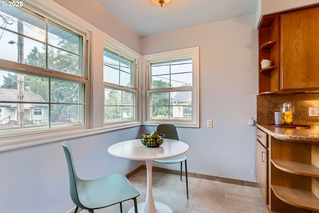 dining room with light tile patterned floors and baseboards