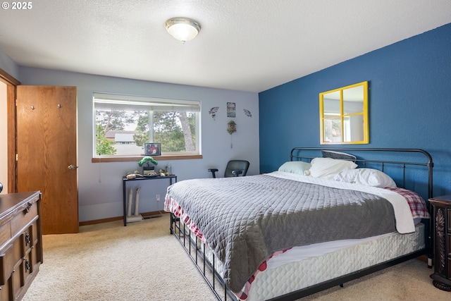 carpeted bedroom featuring a textured ceiling and baseboards