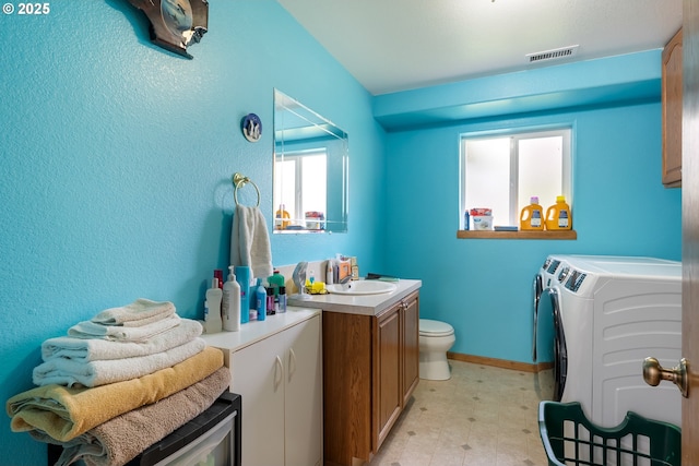 bathroom featuring washer and dryer, vanity, toilet, and tile patterned floors