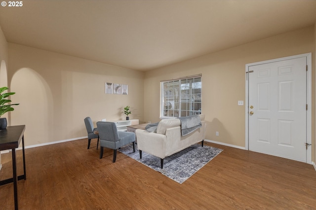 living area with baseboards and wood finished floors