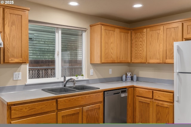 kitchen featuring a sink, stainless steel dishwasher, recessed lighting, and freestanding refrigerator