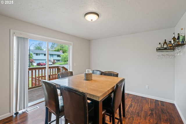790 SE Robin Way, Gresham, OR 97080 - dining area featuring dark wood-type flooring, baseboards, and a textured ceiling