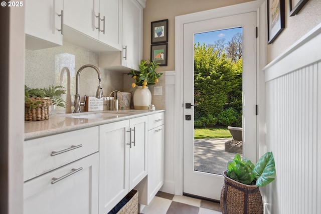 doorway with light floors and a sink