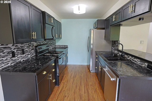 650 S Cammann St, Coos Bay, OR 97420 - kitchen featuring black appliances, light wood-style flooring, backsplash, and dark stone counters