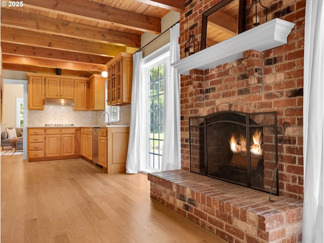 kitchen featuring light countertops, light brown cabinets, light wood finished floors, and dishwasher