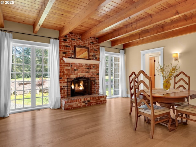 dining space featuring a healthy amount of sunlight, wood ceiling, beamed ceiling, and wood finished floors