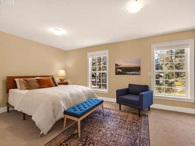 carpeted bedroom featuring baseboards and multiple windows