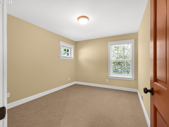 carpeted spare room with baseboards