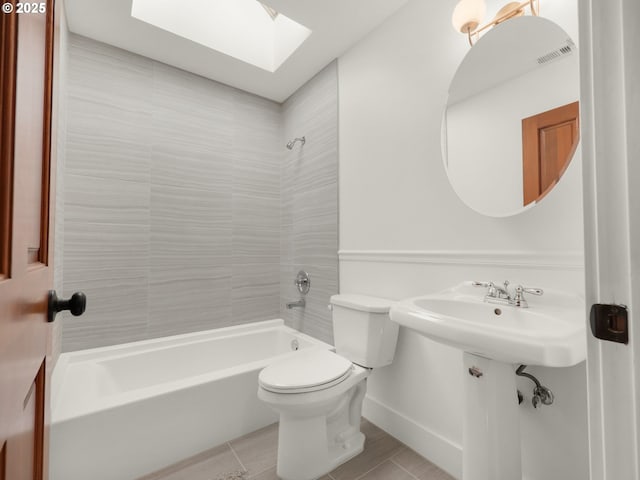full bath with visible vents, bathing tub / shower combination, toilet, baseboards, and a skylight