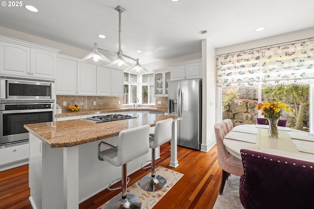 12696 NW Alsace Ln, Portland, OR 97229 - kitchen with stainless steel appliances, recessed lighting, a kitchen island, white cabinets, and decorative backsplash