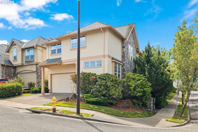 12696 NW Alsace Ln, Portland, OR 97229 - townhome / multi-family property with a garage, stone siding, and concrete driveway