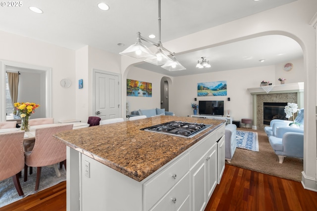 12696 NW Alsace Ln, Portland, OR 97229 - kitchen featuring arched walkways, stainless steel gas stovetop, open floor plan, dark wood-style floors, and white cabinetry
