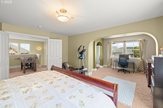 12696 NW Alsace Ln, Portland, OR 97229 - carpeted bedroom with arched walkways, baseboards, and a desk