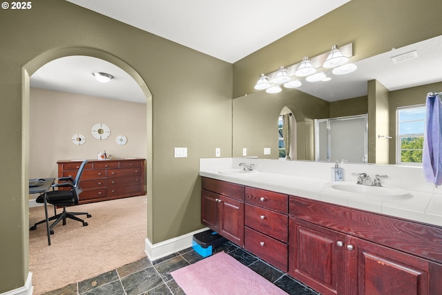 12696 NW Alsace Ln, Portland, OR 97229 - full bath with double vanity, a shower stall, stone finish flooring, and baseboards