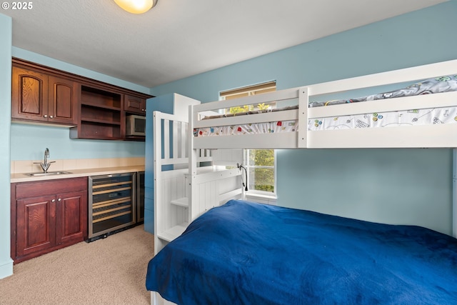 12696 NW Alsace Ln, Portland, OR 97229 - bedroom with wine cooler, bar with sink, and light colored carpet