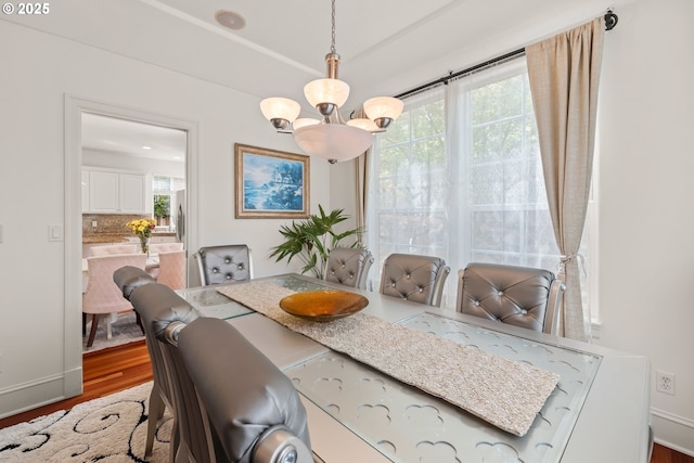 12696 NW Alsace Ln, Portland, OR 97229 - dining space featuring wood finished floors, a chandelier, and baseboards