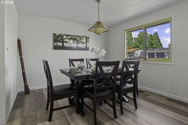 5323 Verda Ln, Keizer, OR 97303 - dining room with wood finished floors, a chandelier, a textured ceiling, and baseboards