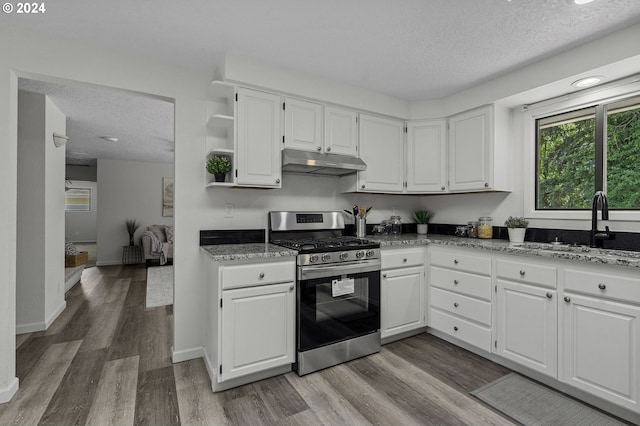 5323 Verda Ln, Keizer, OR 97303 - kitchen featuring stainless steel gas range oven, under cabinet range hood, a textured ceiling, light wood-style floors, and open shelves