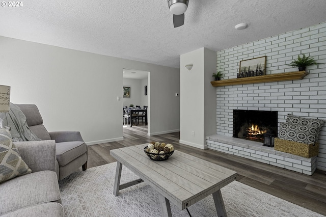 5323 Verda Ln, Keizer, OR 97303 - living room featuring a ceiling fan, wood finished floors, a fireplace, baseboards, and a textured ceiling