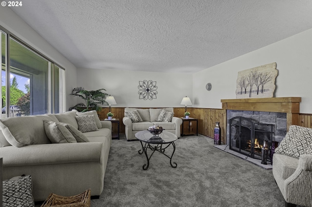 5323 Verda Ln, Keizer, OR 97303 - carpeted living room featuring a wainscoted wall, wooden walls, a stone fireplace, and a textured ceiling