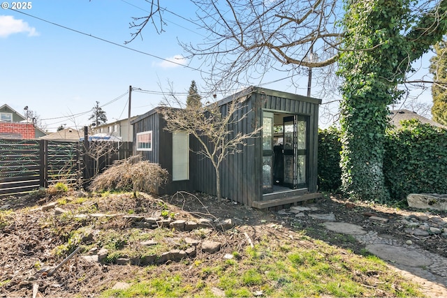 view of outdoor structure featuring an outbuilding and fence