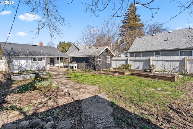 back of house featuring a patio, a lawn, fence, and a garden