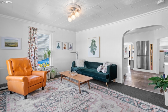 living room featuring arched walkways, wood finished floors, and crown molding