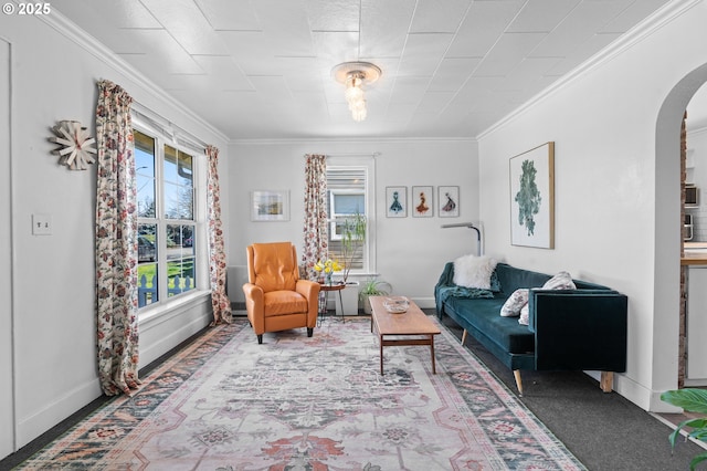 living area with ornamental molding, arched walkways, and baseboards