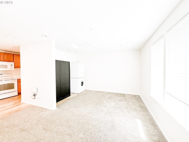spare room with light colored carpet and baseboards