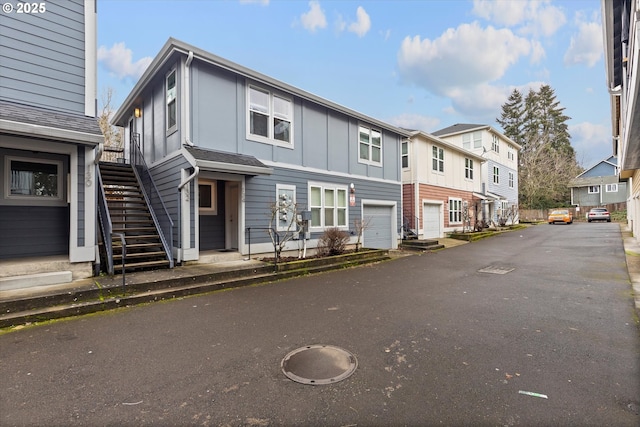 view of property with board and batten siding, a residential view, and stairway