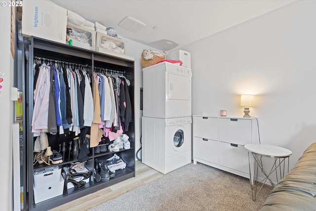 laundry room featuring stacked washer / dryer and wood finished floors