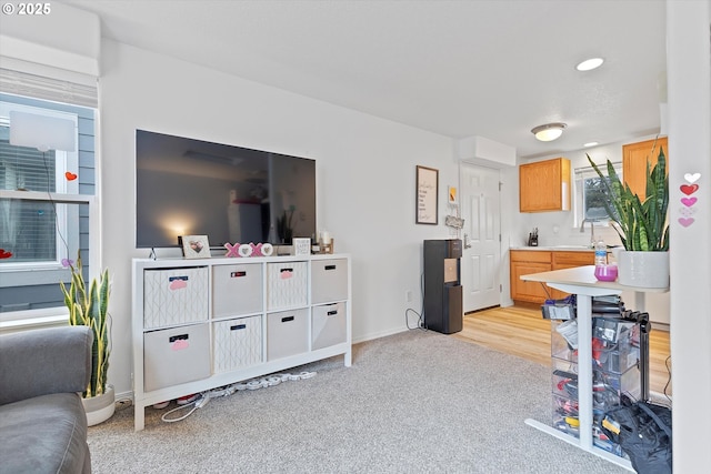 living area with light carpet, recessed lighting, and baseboards