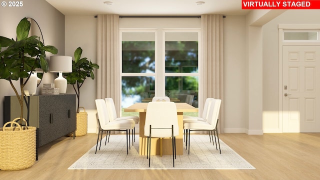 dining space featuring baseboards and wood finished floors