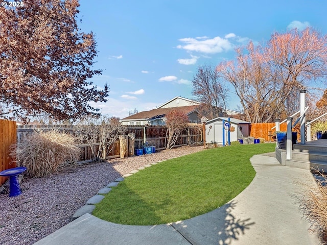 view of yard featuring an outbuilding, a storage unit, and a fenced backyard