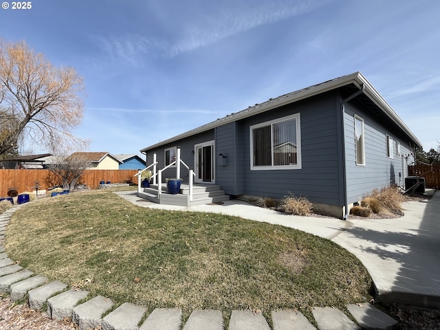 ranch-style house with entry steps, a front yard, and fence