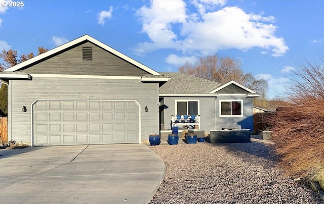 ranch-style home featuring a garage, driveway, and a shingled roof