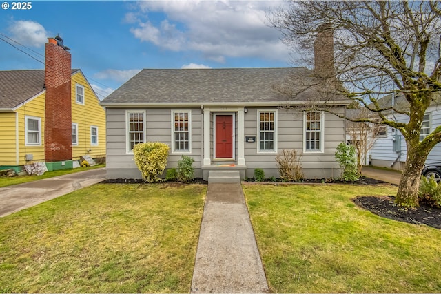 view of front of home featuring roof with shingles and a front yard