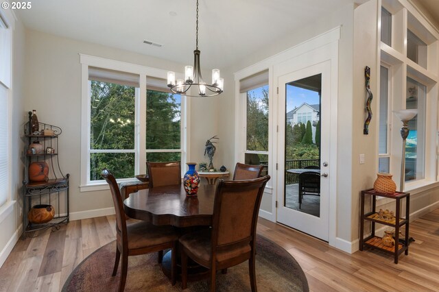 dining space with an inviting chandelier and light hardwood / wood-style flooring