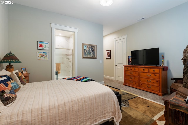 bedroom with connected bathroom and carpet floors