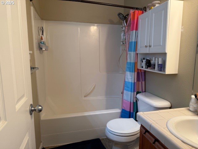 bathroom featuring toilet, vanity, and shower / bath combo with shower curtain