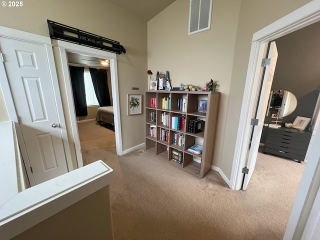 hall featuring carpet flooring and baseboards