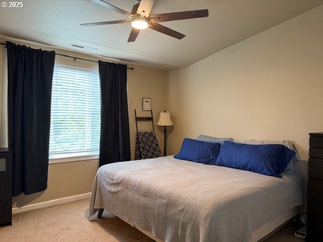 9575 SW Tephra Ter, Beaverton, OR 97007 - carpeted bedroom featuring multiple windows, baseboards, and ceiling fan