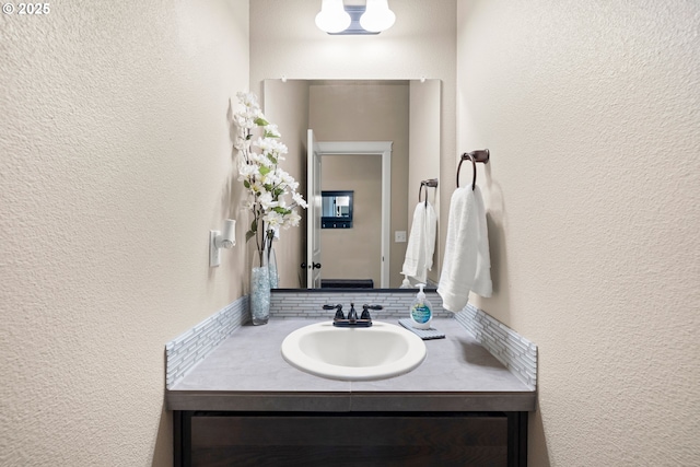 bathroom featuring a textured wall and vanity